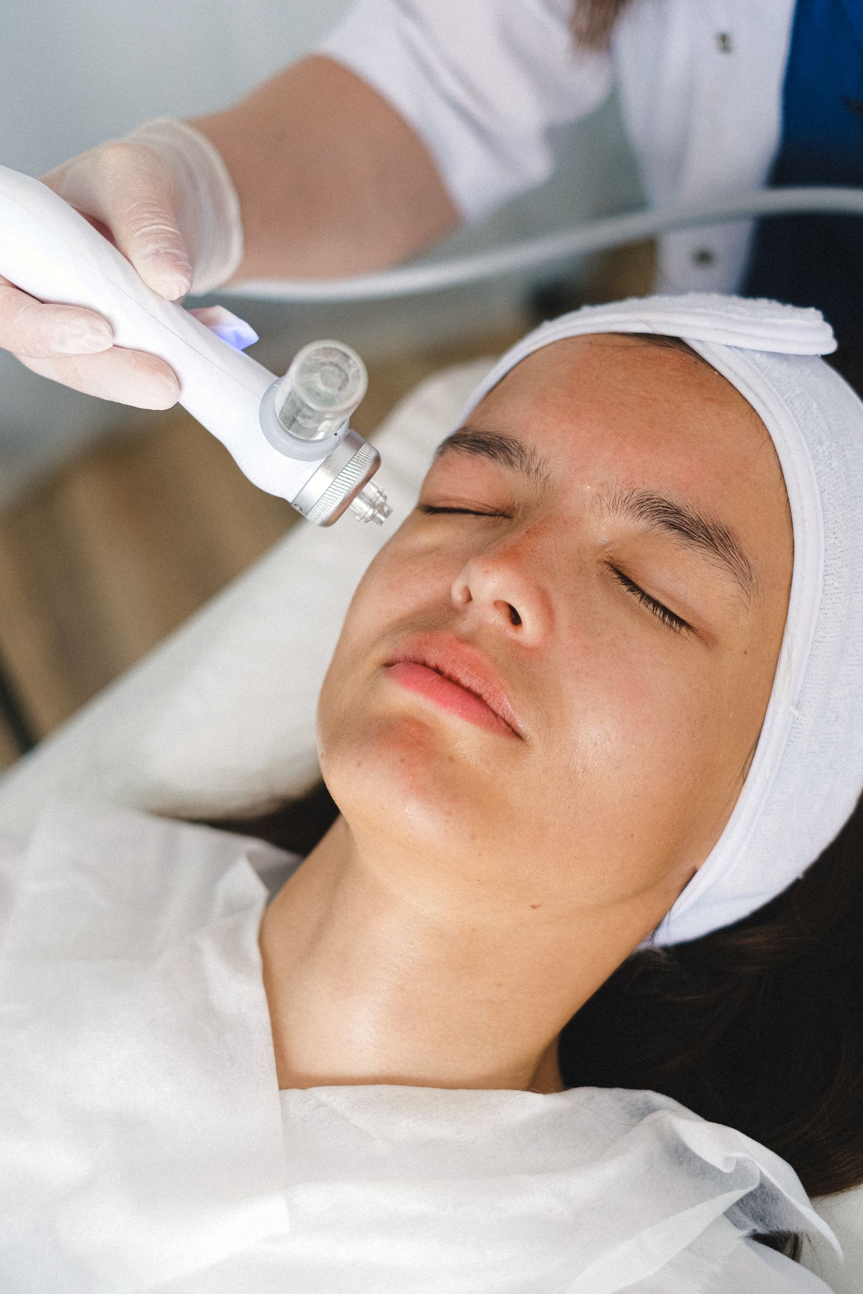 High angle of crop doctor in protective gloves using ultrasound equipment for treatment therapy in beauty salon